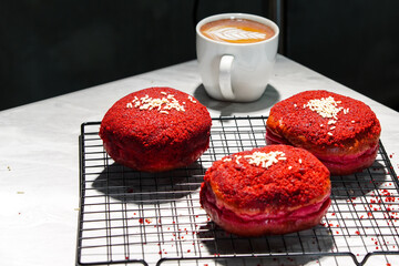 Delicious red velvet donuts on a white table. Red velvet doughnuts topped with cheese.