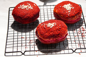 Delicious red velvet donuts on a white table. Red velvet doughnuts topped with cheese.