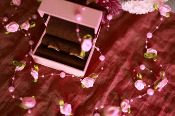 romantic flat lay of wedding ring box on pink velvet with floral details