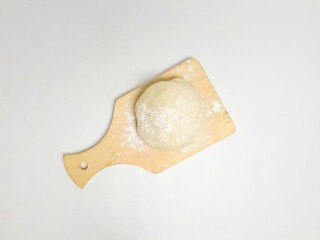 Soft and chewy floured cookie dough on a wooden board, isolated on a white background. Minimalist food concept.