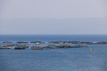 Fish farming cages and yacht offshore in calm Mediterranean sea France, Corsica, Ajaccio, 13 June 2025