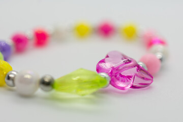 Colorful bracelet with a pink butterfly charm. The bracelet is made of beads and has a colorful crystal charms.