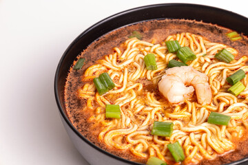 Delicious shrimp ramen in a black bowl garnished with green onions, highlighting the vibrant flavors and rich broth