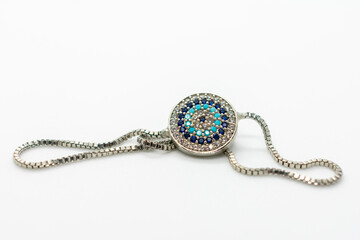 Blue and white necklace with a blue stone in the center. The stone is surrounded by smaller stones...