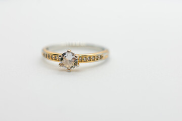 Gold and silver ring with a small diamond in the center. The ring is set in a gold band and has a gold band.