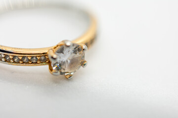 Gold and silver ring with a small diamond in the center. The ring is set in a gold band and has a gold band.