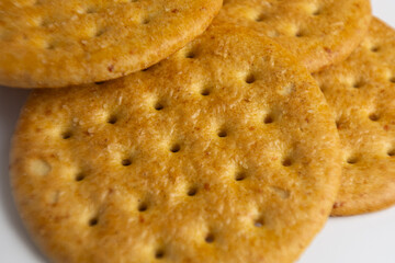 Golden baked crackers arranged in a close-up display showcasing their texture and color on a white background during an afternoon snack time