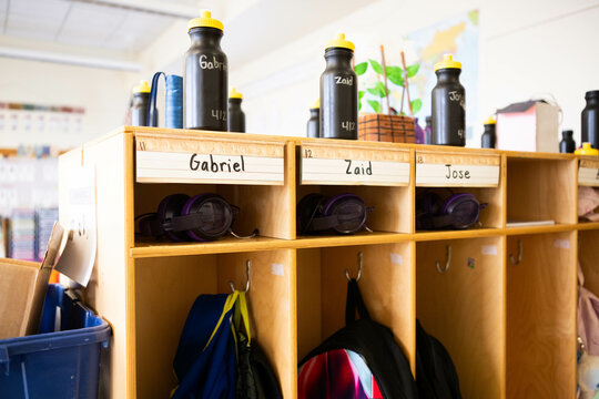 Organized student storage cubbies in elementary school classroom with school supplies and name labels for a diverse set of students, including Zaid, Gabriel, and Jose.