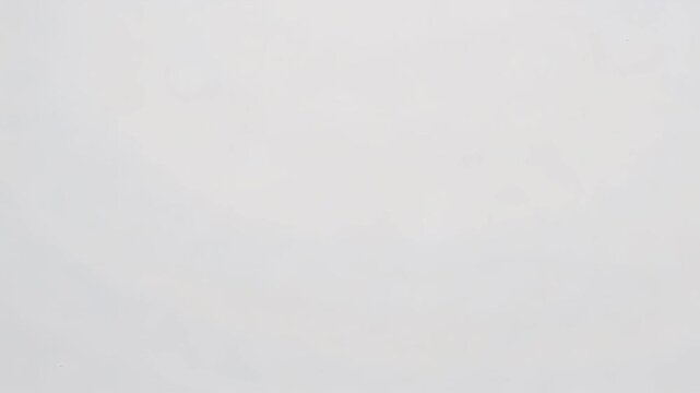 A simple white background with subtle variations in tone and texture across the entire surface area