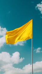 Yellow flag waving on blue sky, vertical background