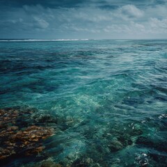 Fototapeta premium Serene Crystal Clear Ocean Water with Gentle Waves and Cloudy Sky