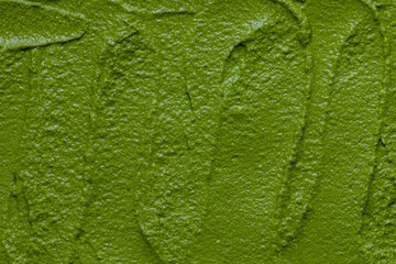 Arugula pesto made of arugula leaves, walnuts, parmesan, garlic, and olive oil, prepared for freezing. Background texture.