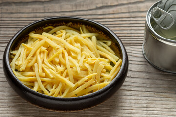 Canned bamboo shoots in bowl. Empty tin can on the side. An important ingredient in Asian cuisine. Rustic wooden table. 