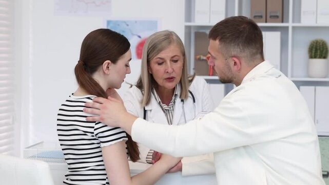 In vitro fertilization (IVF). Man supporting his worried wife during consultation with doctor in reproductive clinic