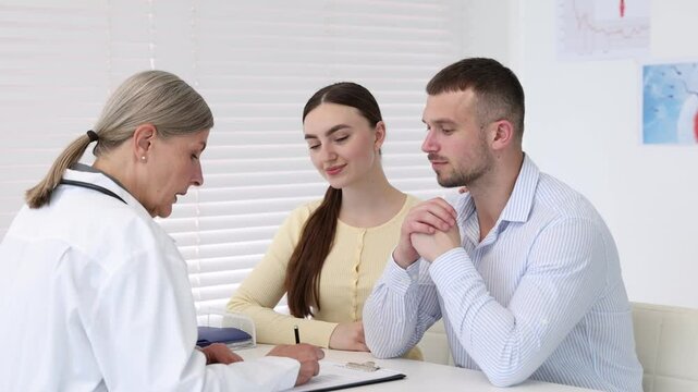 In vitro fertilization (IVF). Happy couple having consultation with doctor in reproductive clinic
