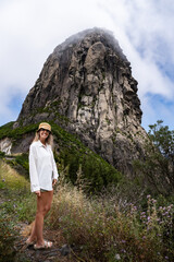 Tourist woman enjoying roque de agando, volcanic rock formation in la gomera, canary islands