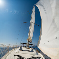 White sails filled with wind, seen from the bow of a sailing yacht near Croatia. Freedom, clean...