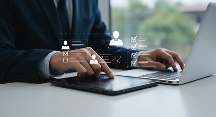 A businessman in a suit uses a tablet and laptop interacting with a digital interface displaying employee profiles and task lists with checkmarks signifying hr management or performance tracking