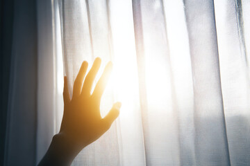 Hand silhouette sunlight curtain window morning soft touch hope gentle. hand silhouette reaches toward sunlight through thin white curtain creating soft and hopeful morning atmosphere