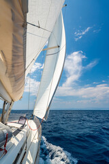 Side of a sailing yacht cutting through the sea with full sails near Croatia. Motion, freedom, sailing lifestyle and adventure on the open water.