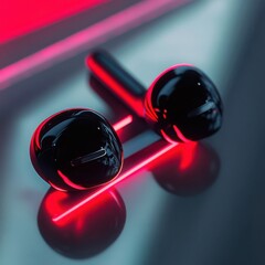 Modern wireless black earbuds with neon red light reflections on reflective surface