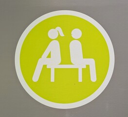 Símbolo circular de área para descansar con silueta de hombre y mujer sentados en un banco 