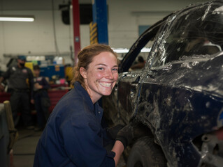 Female Auto Mechanic Smiling While Working on Car