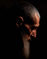 Contemplative Elder in Shadow with Cloak