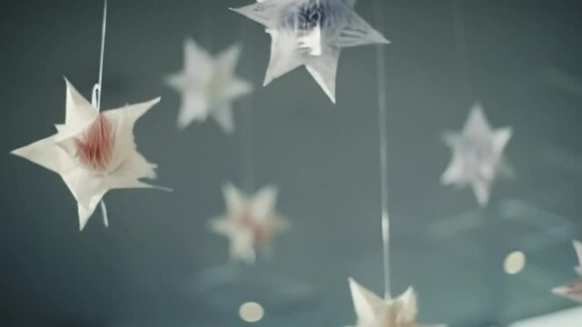 Hanging white paper stars on soft gray background