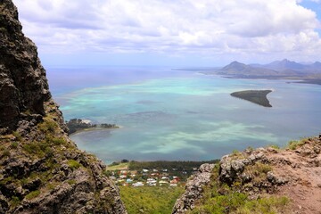 Sweeping coastal view from Le Morne Brabant, Mauritius: rugged volcanic cliffs meet turquoise lagoon waters, coral reefs, and lush island scenery&mdash;perfect for travel, nature, and adventure themes.