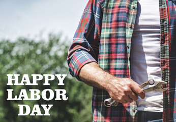 Happy Labor Day. Handsome man and spanners. Closeup, outdoors. Sun day, Congratulations for family, loved ones, friends and colleagues. Concept of preparation for the national holiday