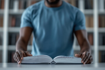 Man carefully reading a large, open book on a table in a library, reflecting dedication to learning and the pursuit of knowledge in a serene and focused environment