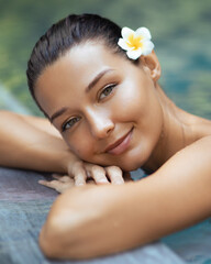 Happy Woman Relaxing at Pool Edge with Radiant Skin and Tropical Vibe
