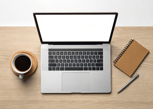 A top down view of a modern silver laptop with a blank white screen a cup of black coffee on a wooden coaster a brown notebook and a silver pen on a light wood grain desk - Powered by Adobe