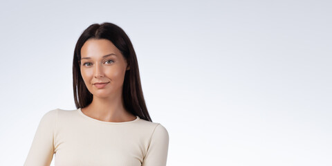 Beautiful Woman With Glowing Skin Wearing Cream Top In Studio Portrait