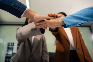business people holding each others wrists, join hands together, support and unity, team strength and power, colleagues involved in team building activity.