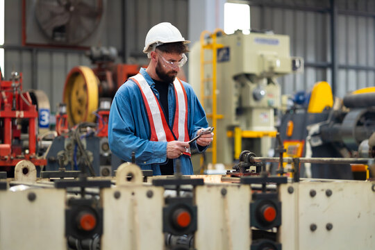 maintenance and service factory : Caucasian man Professional Mechanical Engineer in safety hardhat Working Maintenance sheet metal roof tile roll forming machine at industrial manufacturing factory