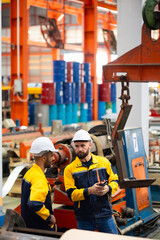 remote control overhead crane : engineer worker working control sheet metal roof machine at metal sheet profiling factory. Industrial production. Service and Maintenance of factory machinery