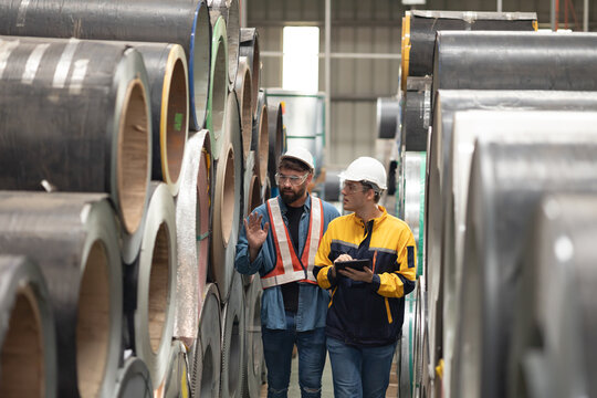 Steel Rolls in Steel Mill. Professional Mechanical Engineer team employees checking production line in wire warehouse. Engineer checking steel rolls. Product quality Inspection