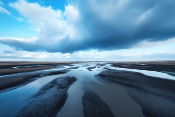 Tranquil tidal flats aerial view dark mud blue sky