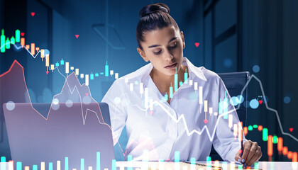 Businesswoman analyzing stock market crash on laptop with falling chart graphics in dark office background during financial crisis concept.