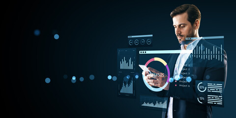 Businessman using smartphone with virtual analytics dashboard and data interface on dark background...