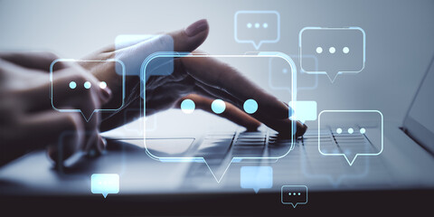 Hands typing on laptop with glowing chat bubble icons overlayed, symbolizing digital communication and social media messaging concept.