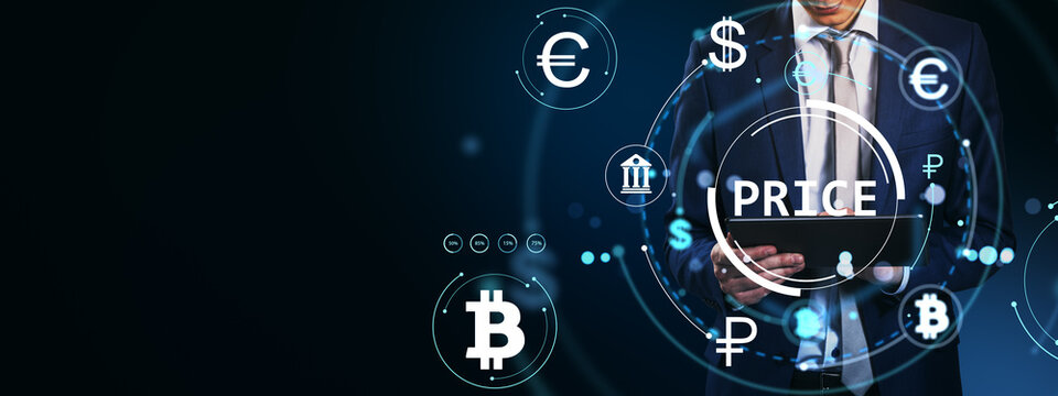 Businessman using tablet with digital currency symbols and price holograms on dark background representing online financial market concept.