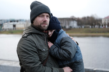 Father and son walking down on sidewalk together. Portrait of a handsome middle-aged man with...