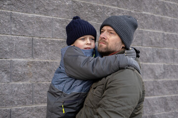 Father and son walking down on sidewalk together. Portrait of a handsome middle-aged man with...