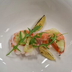 Elegant Seafood Dish with Prawns, Arugula, Grilled Lemon, and Cucumber Garnish