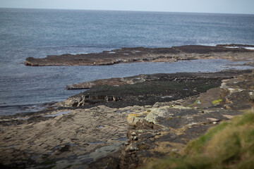A Serene and Picturesque Rocky Shoreline with Calm and Tranquil Waters Await You