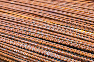 Rusty steel rebar rods arranged in parallel lines at construction site