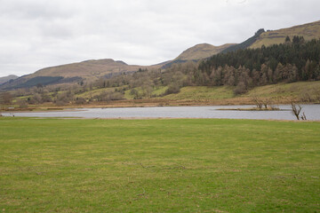 A Beautiful Serene Landscape Featuring a Lake Surrounded by Majestic Mountains in the Background